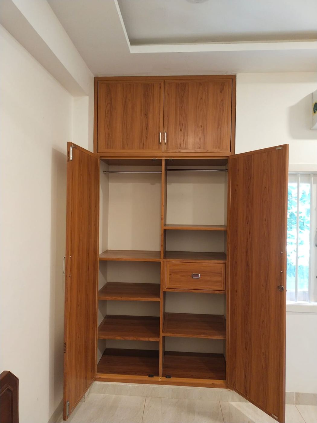 Cream PVC/uPVC cupboard with wood-tone accent panelling installed by No More Wood in Chennai