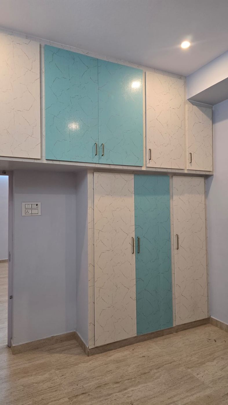 Grey PVC/uPVC wardrobe with wood-tone accent shutter installed by No More Wood in Chennai
